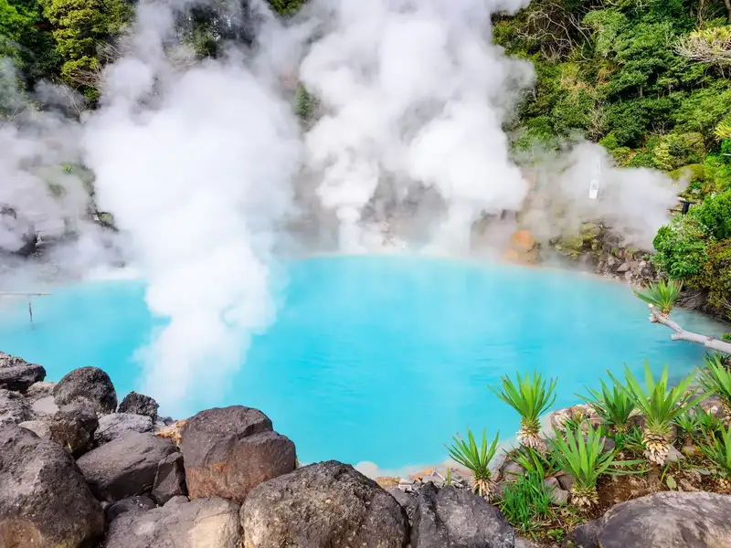 Beppu Hells hotspring steaming and surrounded by lush greenery